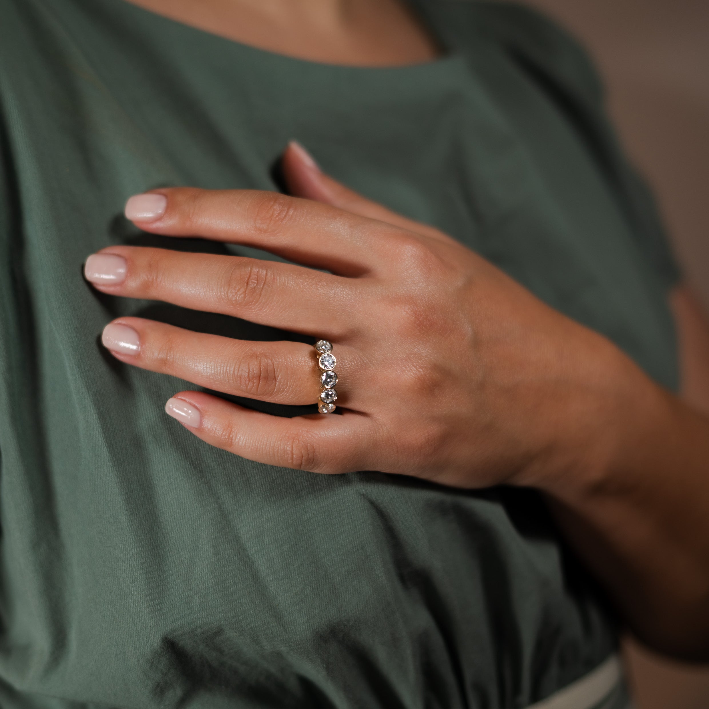 Close-up of a hand wearing a 5-stone diamond ring.