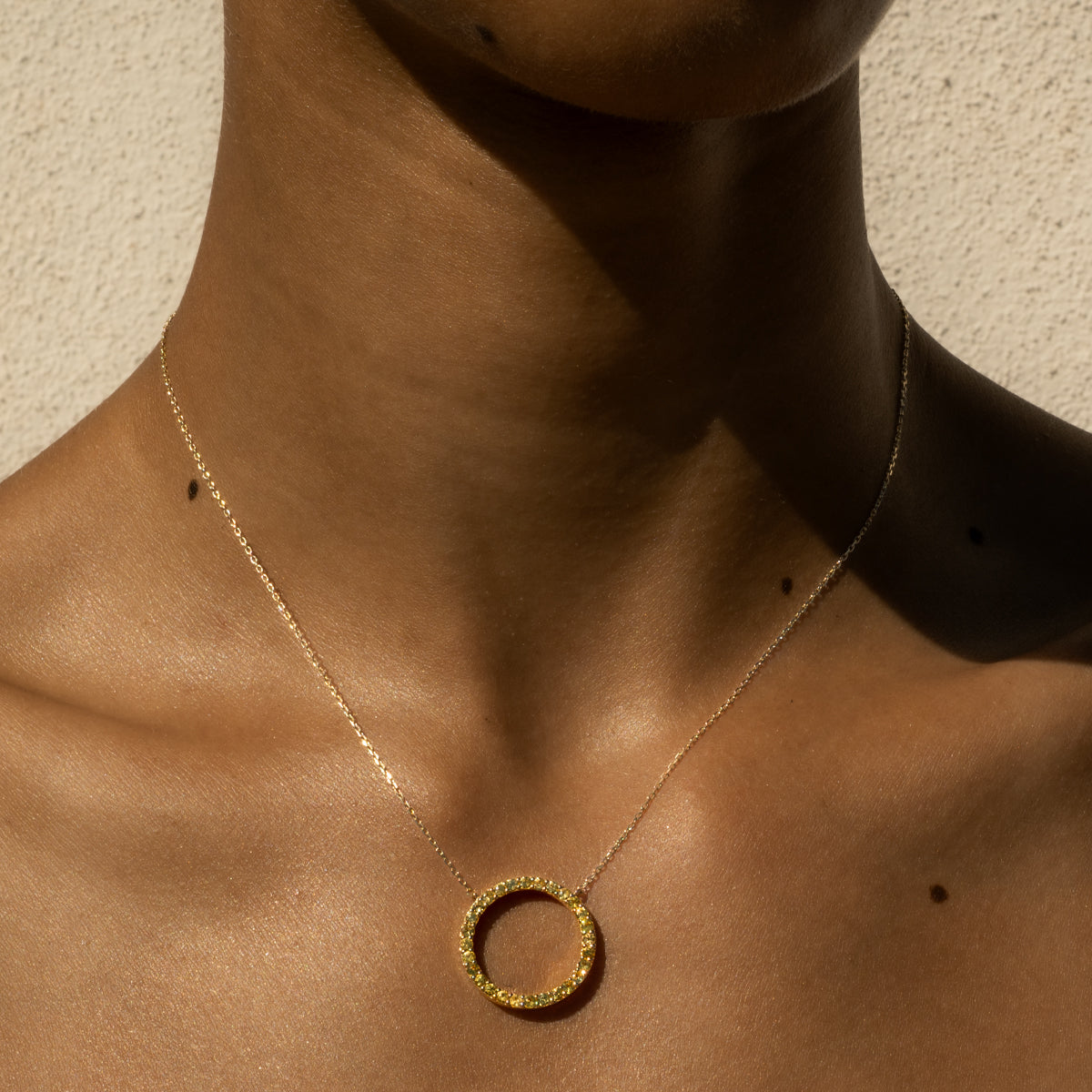 a woman wearing 14K yellow gold princess cut yellow diamond circular necklace