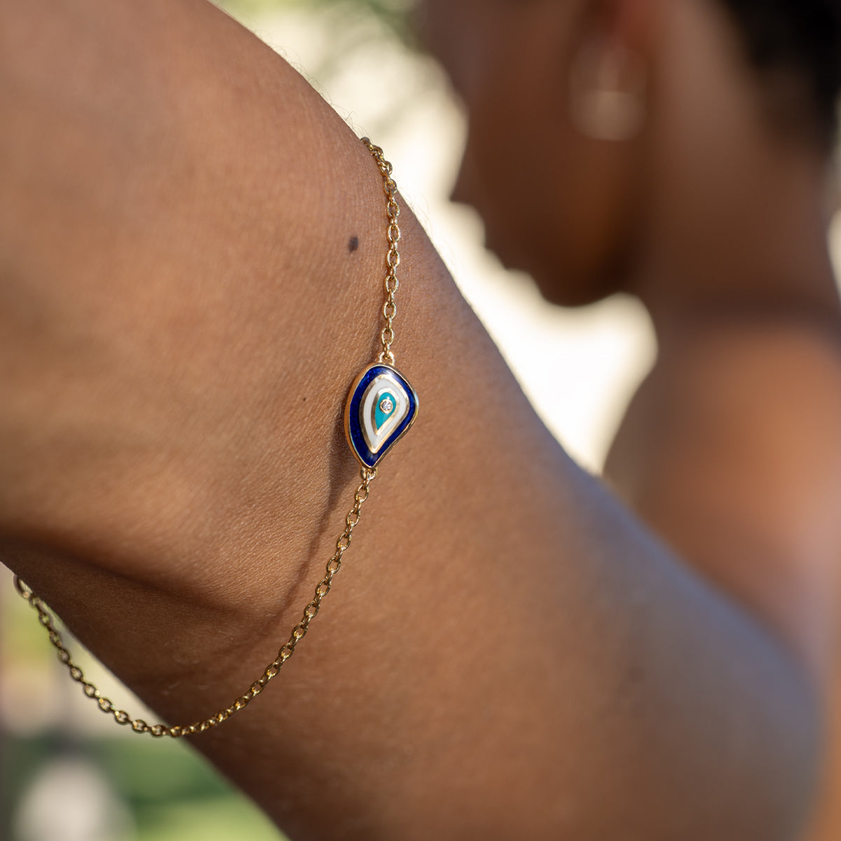 a woman wearing a teardrop shape evil eye diamond bracelet