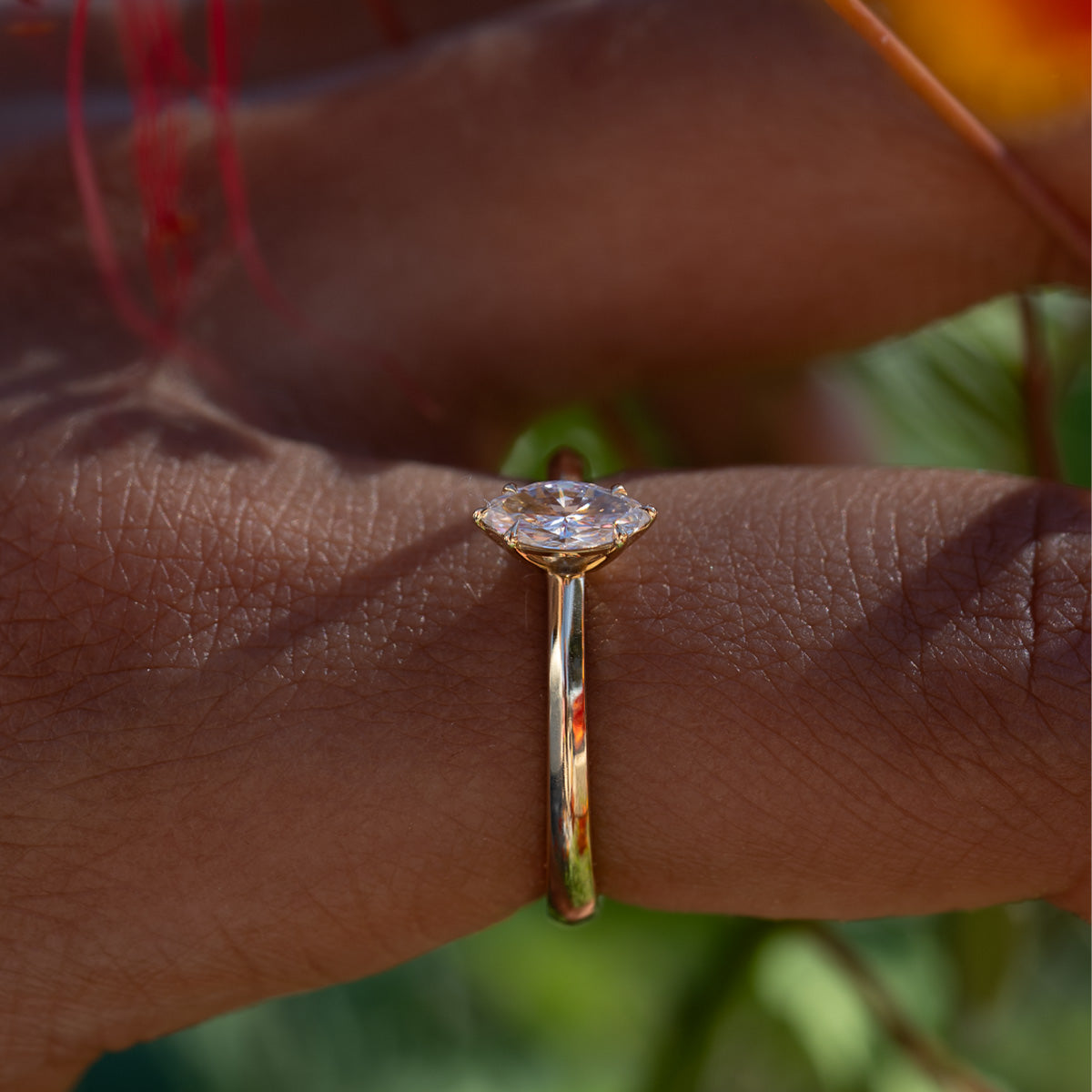 a woman wearing a 14K yellow gold marquise cut diamond solitaire ring