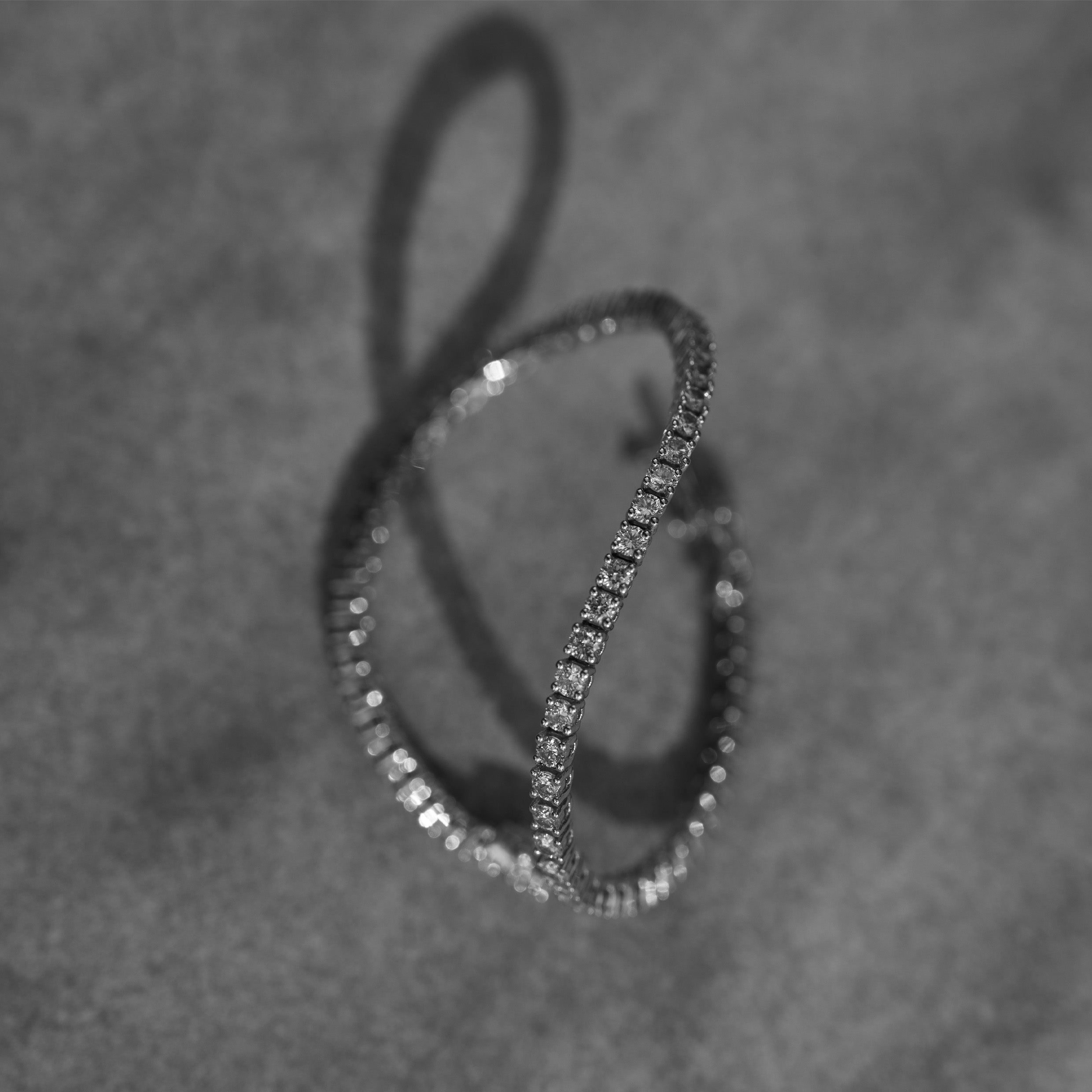 14K gold, diamond tennis bracelet  on a textured gray background