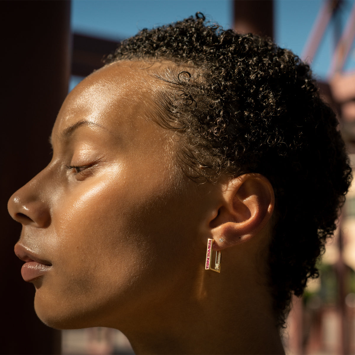 a woman wearing 14K yellow gold princess cut ruby rectangular hoop 