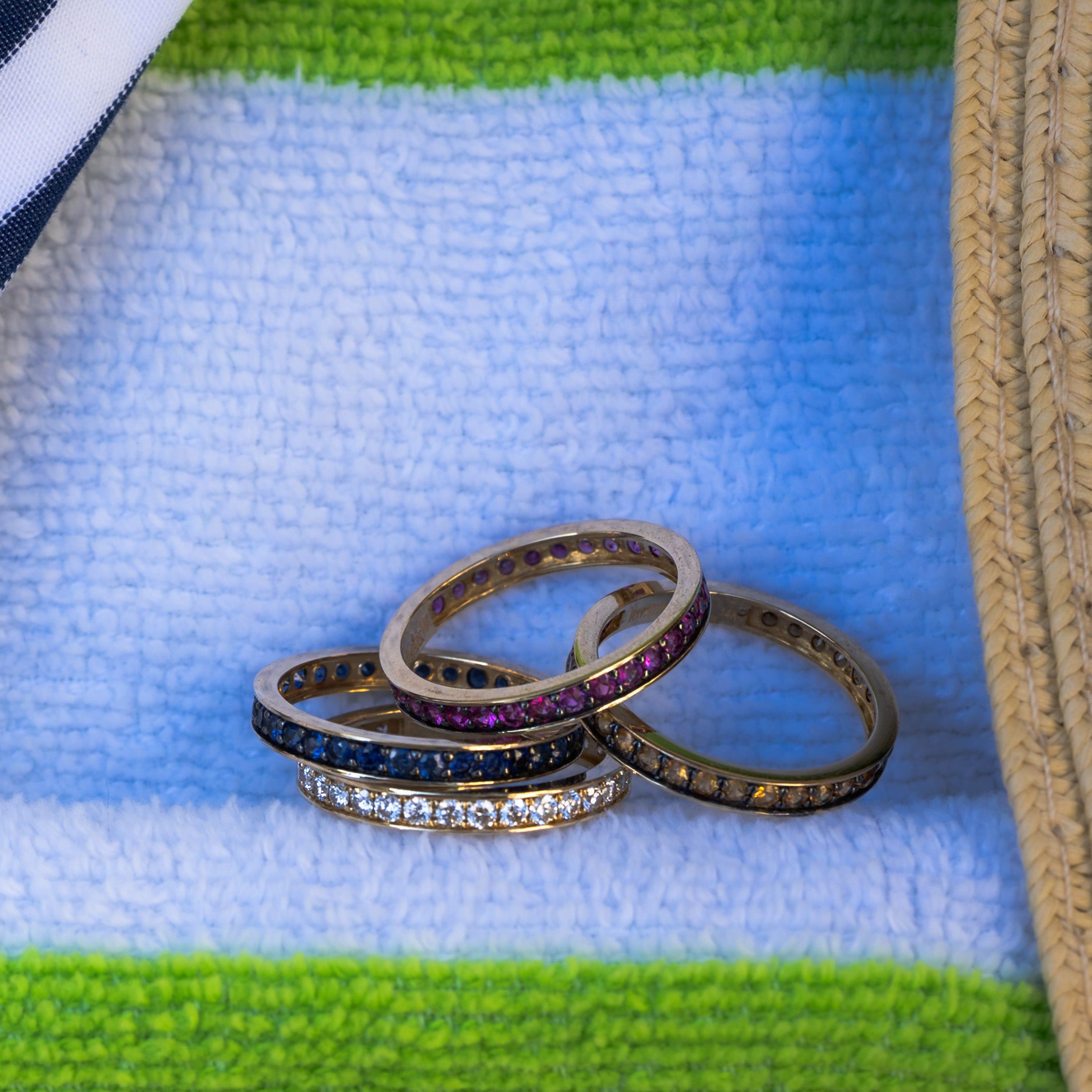 Stack of rings with gemstones on a textured fabric background