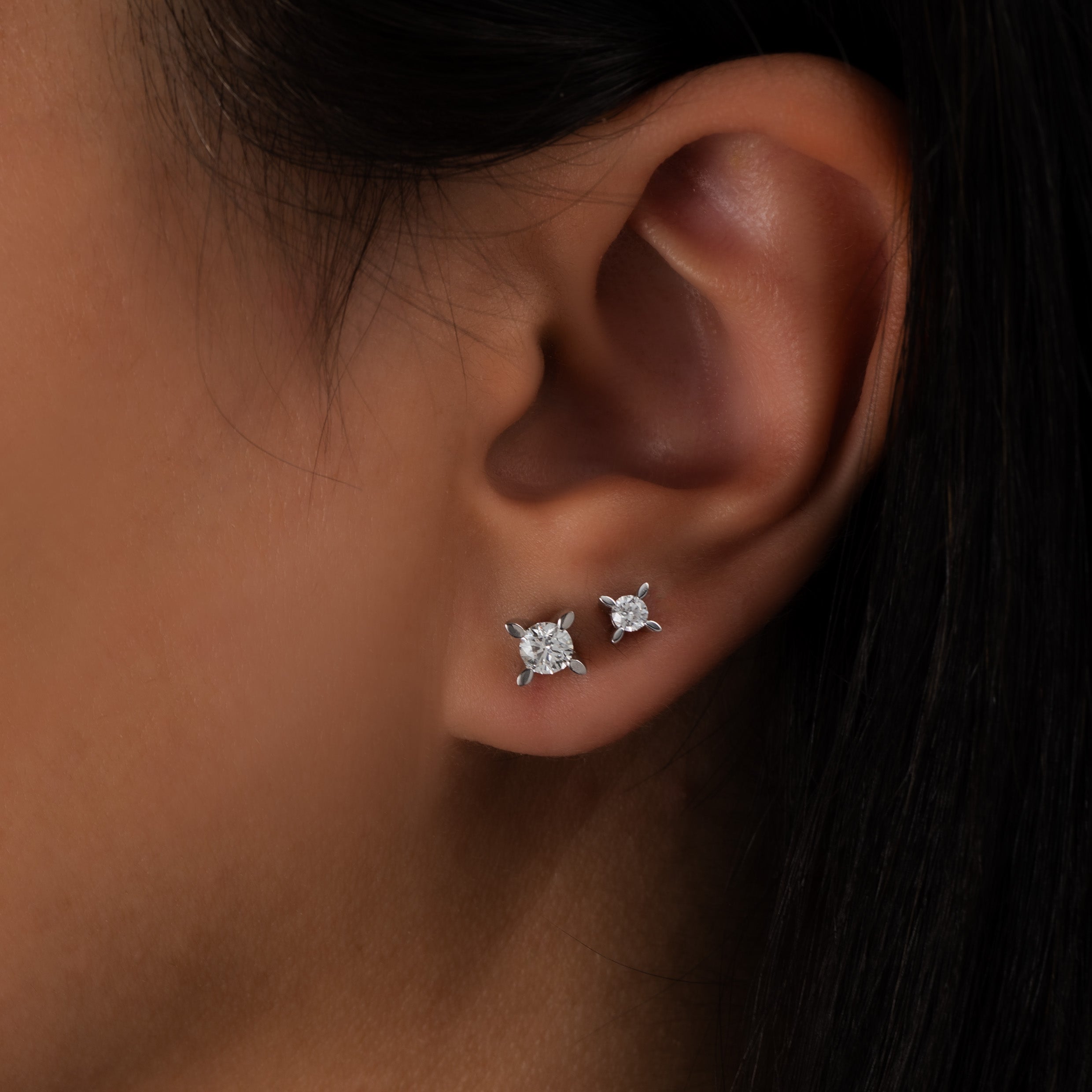 Close-up of an ear wearing diamond studs
